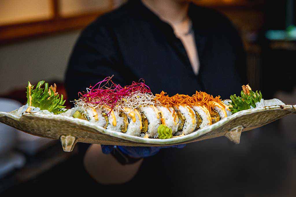 hand holding sushi plate