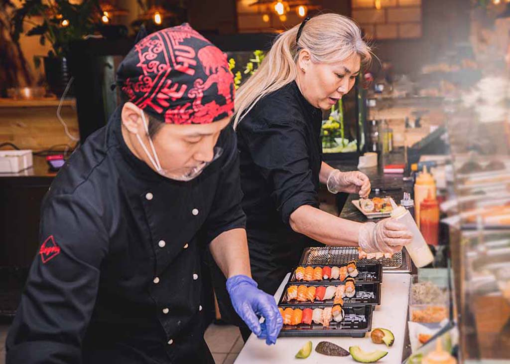two chefs making sushi